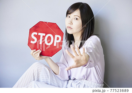Woman has Traffic sign STOP 77523689