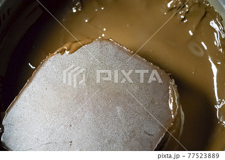 Melted chocolate in a pan under a water bath. Making hot chocolate at home in your own kitchen 77523889