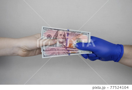 Hand in glove holds dollars with germs. The concept of dirty money as a carrier of bacteria and viruses Hand in glove holds dollars with germs. The concept of dirty money as a carrier of bacteria and viruses 77524104