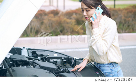 自動車のボンネットを開けてスマホで通話する女性 故障 ロードサービス 自動車のボンネットを開けてスマホで通話する女性 故障 ロードサービス 77528537