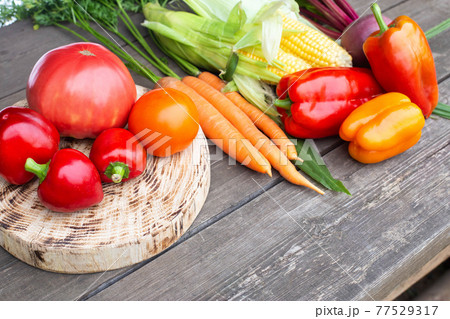 Summer harvest on a wooden table. Assortment of vegetables carrots and tomatoes, bell peppers and beets. Copy space for text, farming Summer harvest on a wooden table. Assortment of vegetables carrots and tomatoes, bell peppers and beets. Copy space for text, farming 77529317