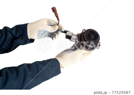 Car locksmith in uniform holds in his hand a car water pump on a white background, isolate. Car water pump wear and tear concept 77529367