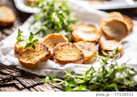 Crispy goldish bake rolls with savory flavour, served with lovely green thyme 77530331