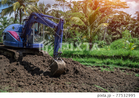 industrial bulldozer excavate ground and soil in tropical rain forest 77532995