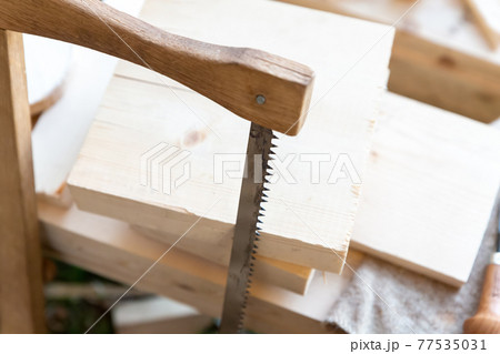 saw for sawing lumber close-up vertically on the background of boards 77535031