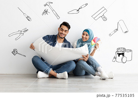 Creative muslim couple working on design for new house Creative muslim couple working on design for new house 77535105
