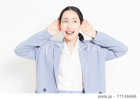 白バックの前に立って、聞き耳を立てる女性 白バックの前に立って、聞き耳を立てる女性 77536666