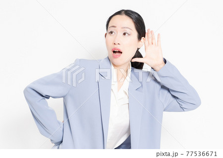白バックの前に立って、聞き耳を立てる女性 白バックの前に立って、聞き耳を立てる女性 77536671