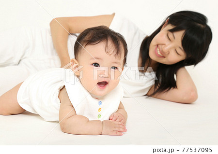白背景で女の子の赤ちゃんと遊ぶ,遊びお母さん。育児,幸福,育児イメージ 77537095