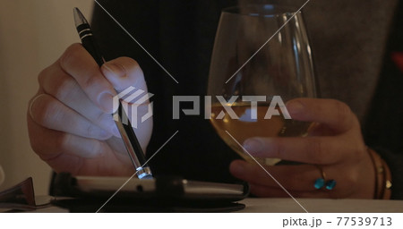 Woman having wine and using cell phone 77539713