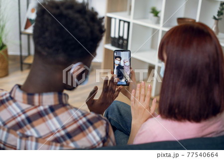 Couple in face masks having video call with muslim friends 77540664