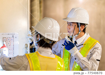 建設現場で配電盤を点検する作業員 建設現場で配電盤を点検する作業員 77540670