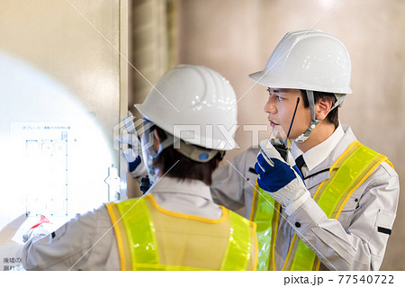 建設現場でトランシーバーを使う作業員 77540722