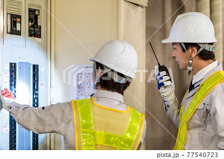 建設現場で配電盤を点検する作業員 77540723
