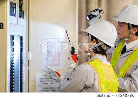 建設現場で配電盤を点検する作業員 77540730