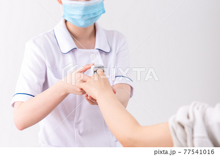 パルスオキシメーターでサチュレーション測定をする看護師 77541016