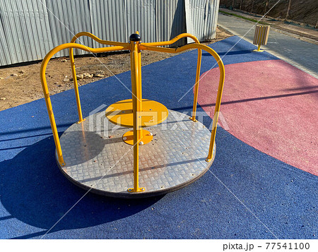Children's round metal blue swing carousel for sports games in the courtyard of a new building on a children's playground 77541100