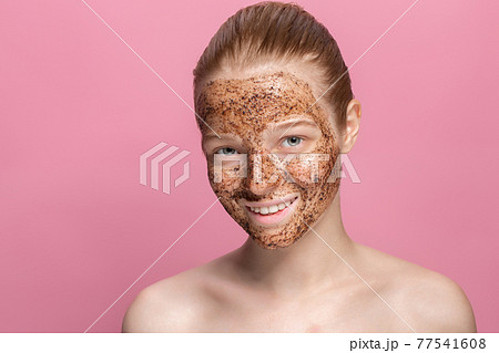 Facial skin scrub Coffee grounds mask on the face of a beautiful young woman Organic natural cosmetology Pink studio background Isolate Facial skin scrub Coffee grounds mask on the face of a beautiful young woman Organic natural cosmetology Pink studio background Isolate 77541608