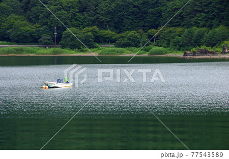 河口湖湖畔にたたずむ一艘の釣り舟 77543589