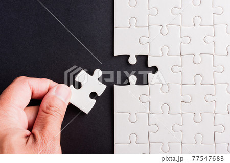 hand-holding last piece white paper jigsaw puzzle game last pieces put to place 77547683