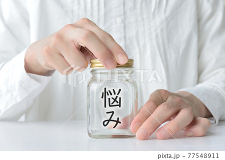 悩みを隠す女性 悩みを隠す女性 77548911