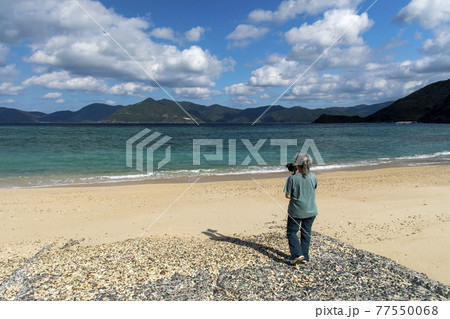奄美群島 加計呂麻島の実久ビーチで動画撮影をする女性フォトグラファー 奄美群島 加計呂麻島の実久ビーチで動画撮影をする女性フォトグラファー 77550068