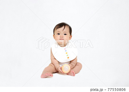 白背景でお座りする女の子の赤ちゃん。成長,健康,元気,育児イメージ 77550806