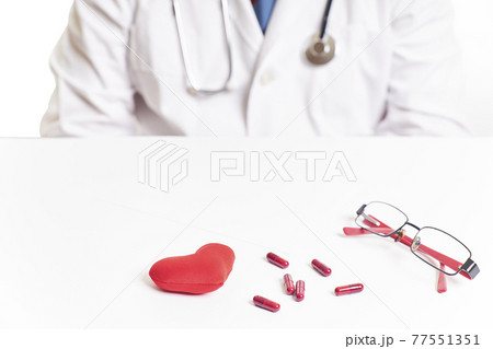 Doctor next to a red heart and pills. Heart checkup. World health day Doctor next to a red heart and pills. Heart checkup. World health day 77551351