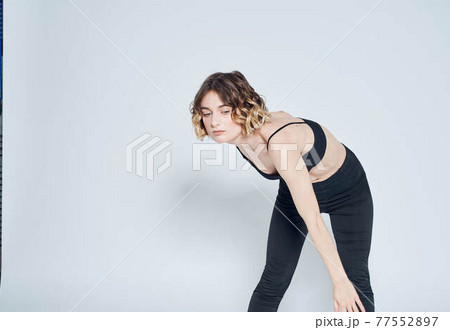 Woman in leggings doing exercises on a light background cropped view of fitness gymnastics Woman in leggings doing exercises on a light background cropped view of fitness gymnastics 77552897