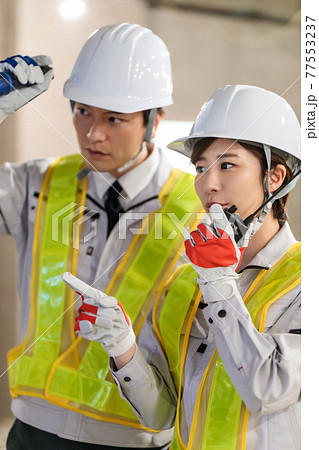 建設現場でトランシーバーを使う作業員 77553237