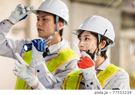 建設現場でトランシーバー(無線機)を使う作業員 77553239