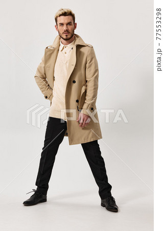 Gentleman in coat feet shoulder width apart and fashion style 77553298