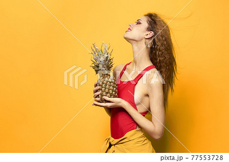 pretty woman with pineapple in her hands cosmetics exotic fruits yellow background fun pretty woman with pineapple in her hands cosmetics exotic fruits yellow background fun 77553728