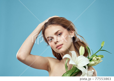 Attractive Lady white flowers blue background portrait cropped view Attractive Lady white flowers blue background portrait cropped view 77553863
