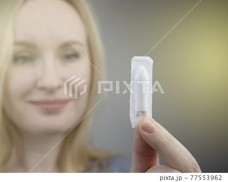 Vaginal or rectal suppository in the hands of a woman. The drug is in the form of suppositories. The concept of treatment of gynecological diseases and diseases of the rectum 77553962