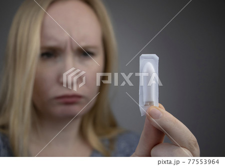 Vaginal or rectal suppository in the hands of a woman. The drug is in the form of suppositories. The concept of treatment of gynecological diseases and diseases of the rectum 77553964