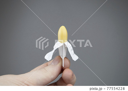 Vaginal or rectal candle in hands on a light background. The drug is in the form of suppositories. The concept of treatment of gynecological diseases and diseases of the rectum 77554228