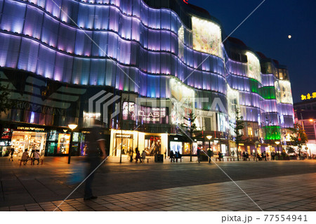 Modern urban building lit up at night 77554941