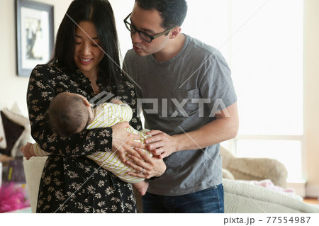 Parents holding baby girl 77554987