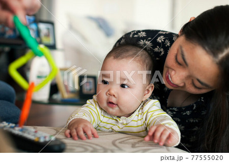 Close up of parents playing with baby daughter 77555020