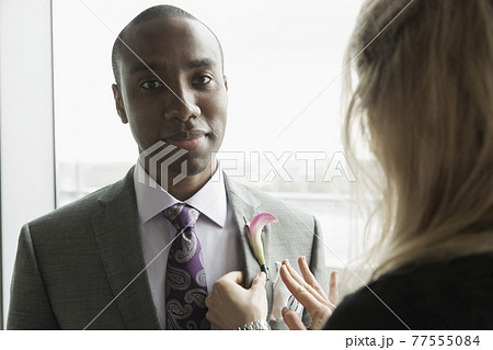 Bridegroom getting ready with help from friend Bridegroom getting ready with help from friend 77555084