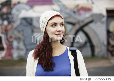 Young woman with long red hair, wearing knitted hat Young woman with long red hair, wearing knitted hat 77555349