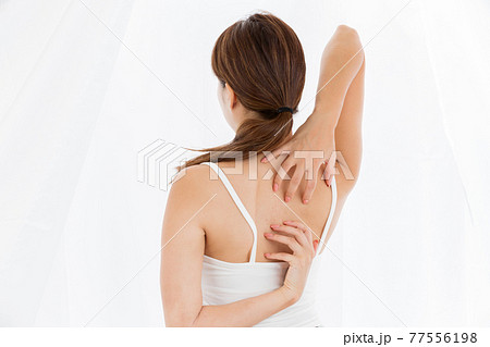 背中を掻く女性 77556198