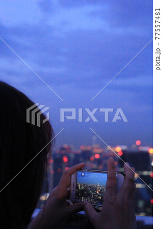 六本木ヒルズスカイデッキ スマホで夜景写真を撮る女性 六本木ヒルズスカイデッキ スマホで夜景写真を撮る女性 77557481