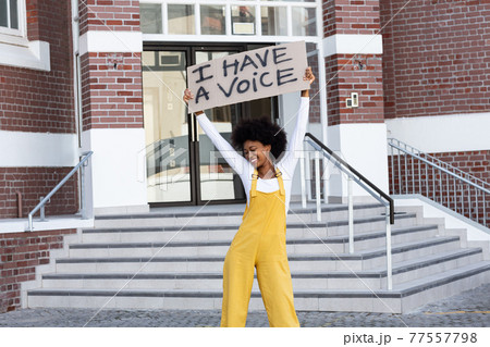 Portrait of mixed race woman holding placard Portrait of mixed race woman holding placard 77557798