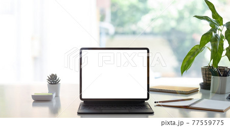 Digital tablet with white blank screen on table. workspace in modern office concept. Digital tablet with white blank screen on table. workspace in modern office concept. 77559775