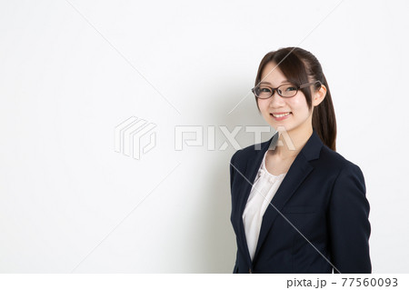 両手を後ろに組み笑っているビジネスウーマン（コピースペース） 77560093