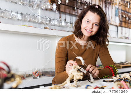 Girl seller offering colored necklaces and pendants Girl seller offering colored necklaces and pendants 77562040
