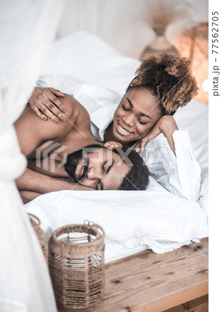 Smiling woman looking at sleeping husband Smiling woman looking at sleeping husband 77562705