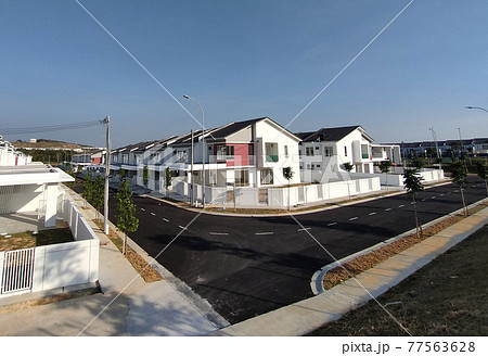 SEREMBAN, MALAYSIA -APRIL 20, 2021: New double story luxury terrace house in Malaysia. Construction almost completed. Designed by an architect with a modern and contemporary style. SEREMBAN, MALAYSIA -APRIL 20, 2021: New double story luxury terrace house in Malaysia. Construction almost completed. Designed by an architect with a modern and contemporary style. 77563628